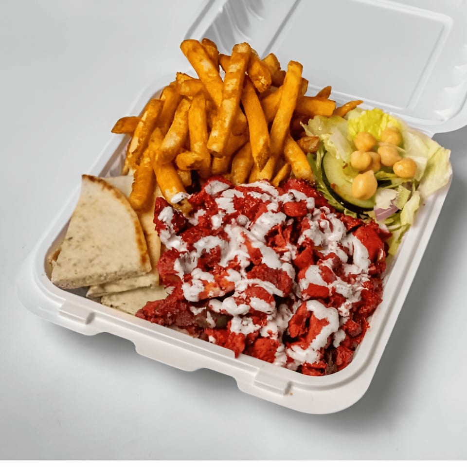 Halal Haven's chicken tikka platter with fries, salad, pita bread, and white sauce.
