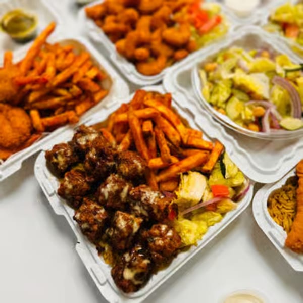 Halal Haven takeout containers filled with fried chicken, fries, shrimp, and salads.